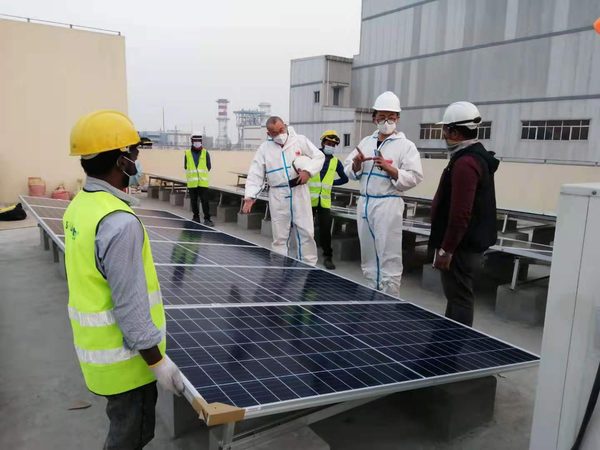 SEDCOL technicians inspecting solar modules on site wearing full PPE