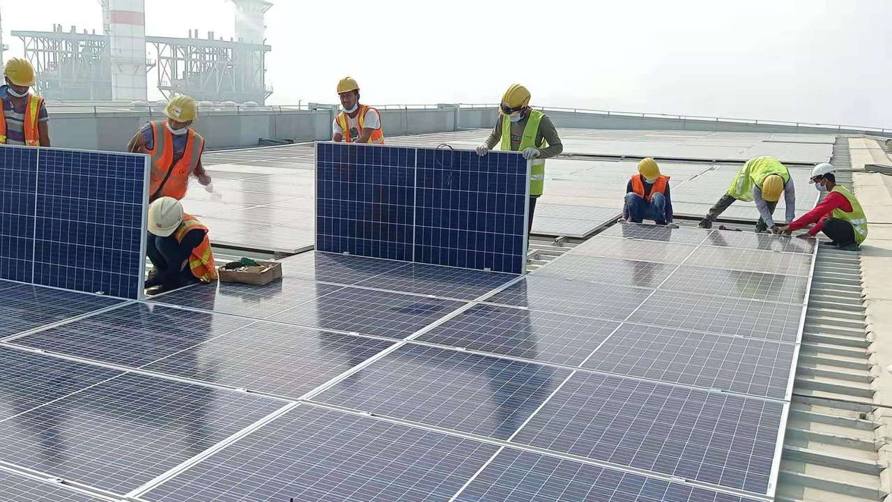 Grid-tied solar array installed across an industrial rooftop under an open sky